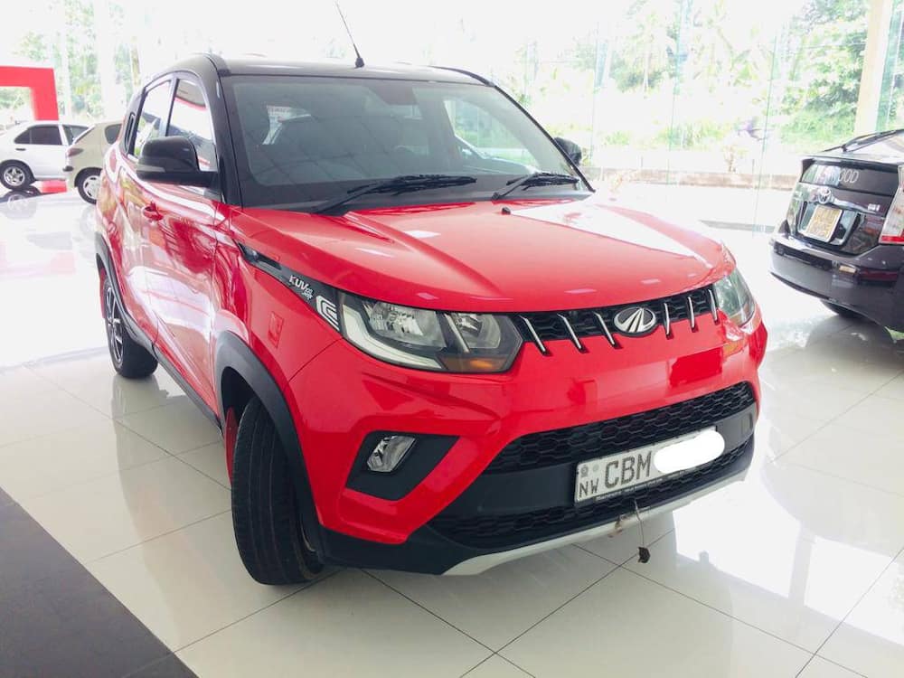 A red Mahindra KUV 100NXT in the yard