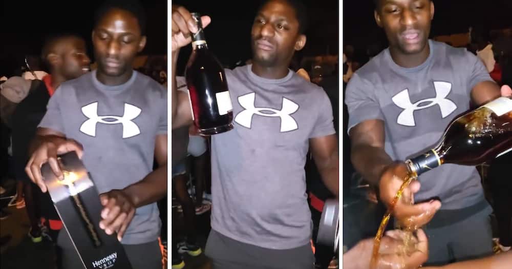 A man flexed with an expensive bottle of Hennessy.