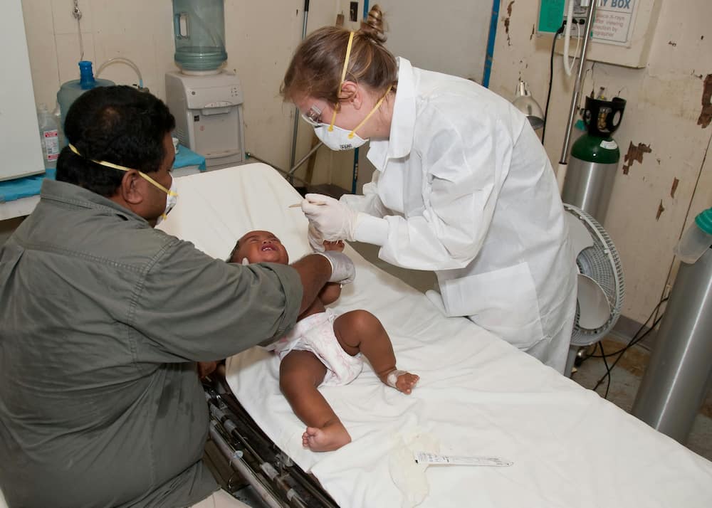 A medic doing a checkup on a small baby