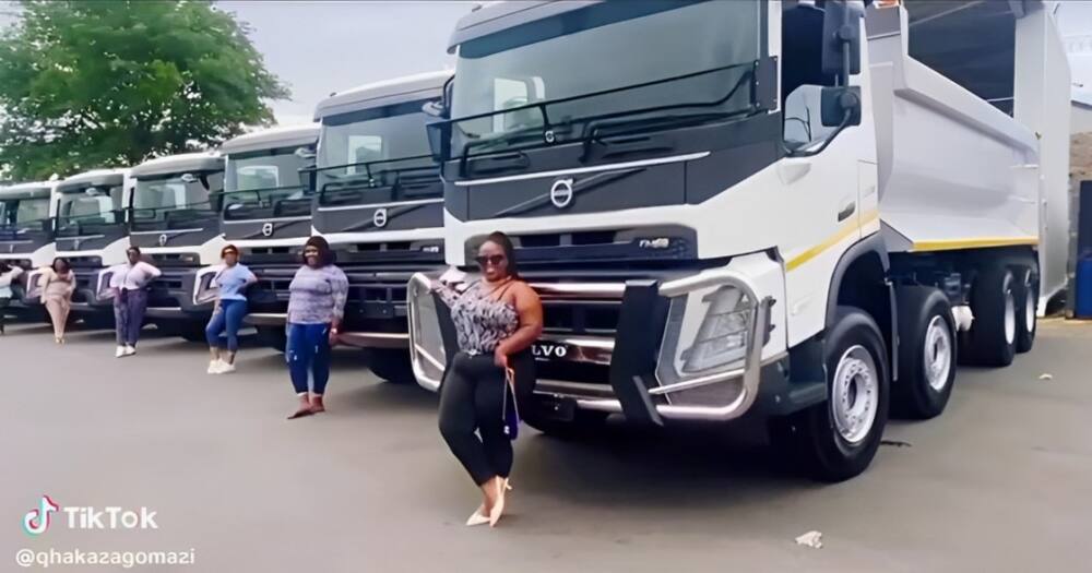 Female truckers posed in front of their vehicles