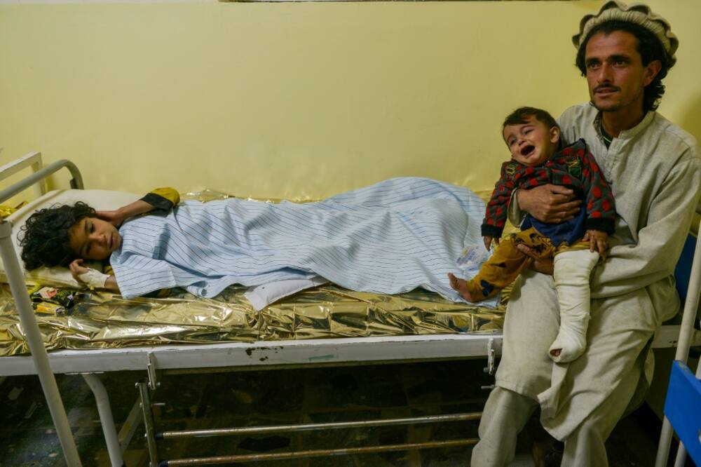 An Afghan man with his injured children at a hospital in Sharan, Paktika province, following the eartrhquake