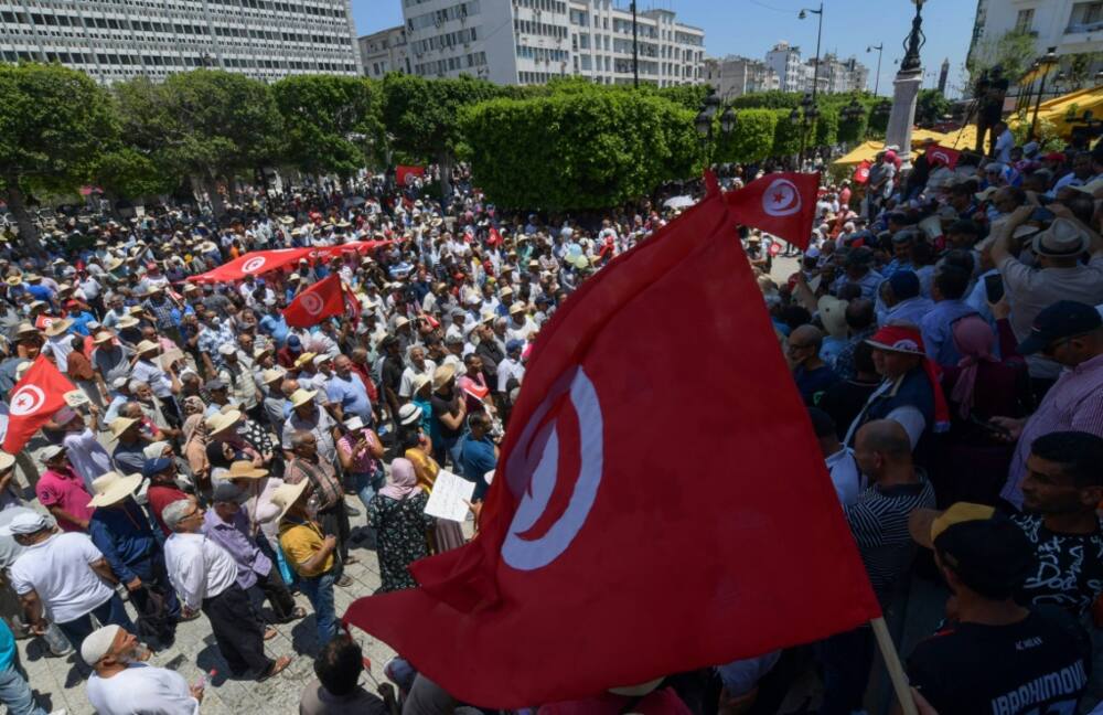 Tunisian protesters wave national flags during a demonstration in the capital Tunis against President Kais Saied and an upcoming July 25 constitutional referendum