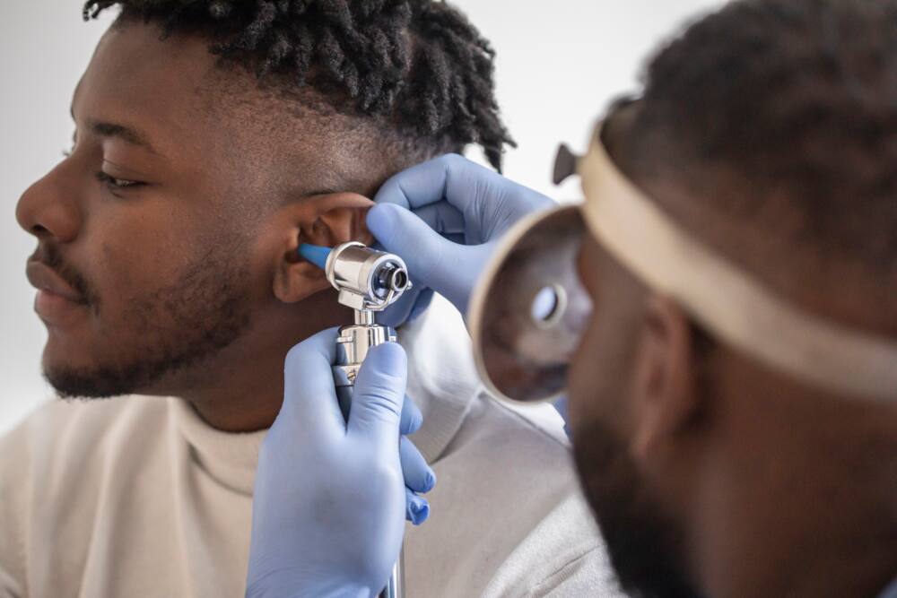 A physician examining the inside of an ear
