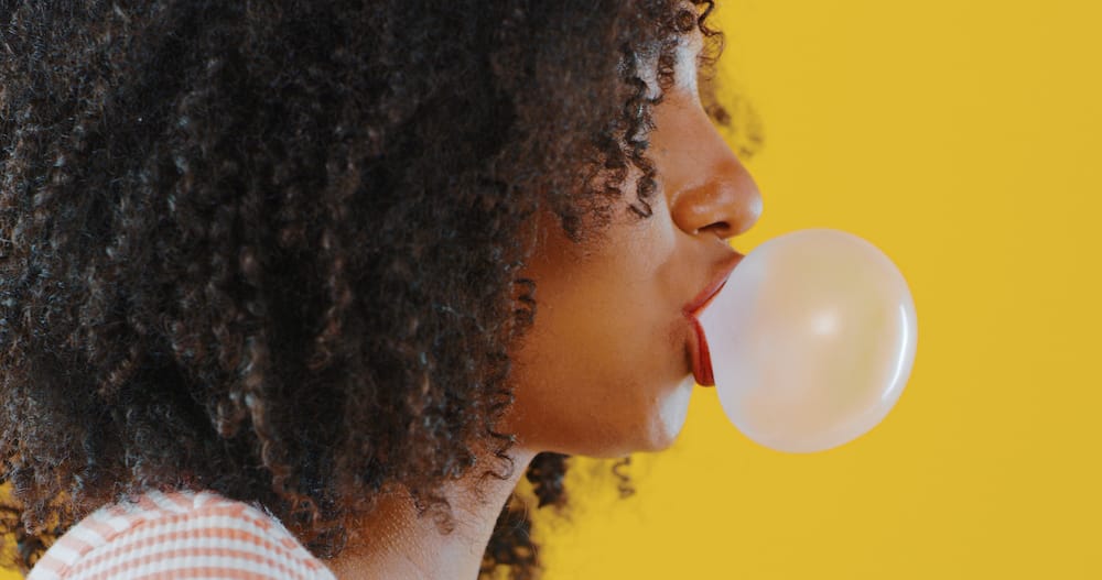 A woman blowing bubblegum