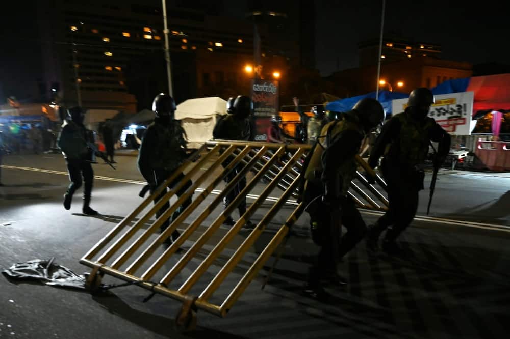 Members of Sri Lankan security forces remove a barricade blocking the main gate of the Presidential Secretariat in Colombo on July 22, 2022
