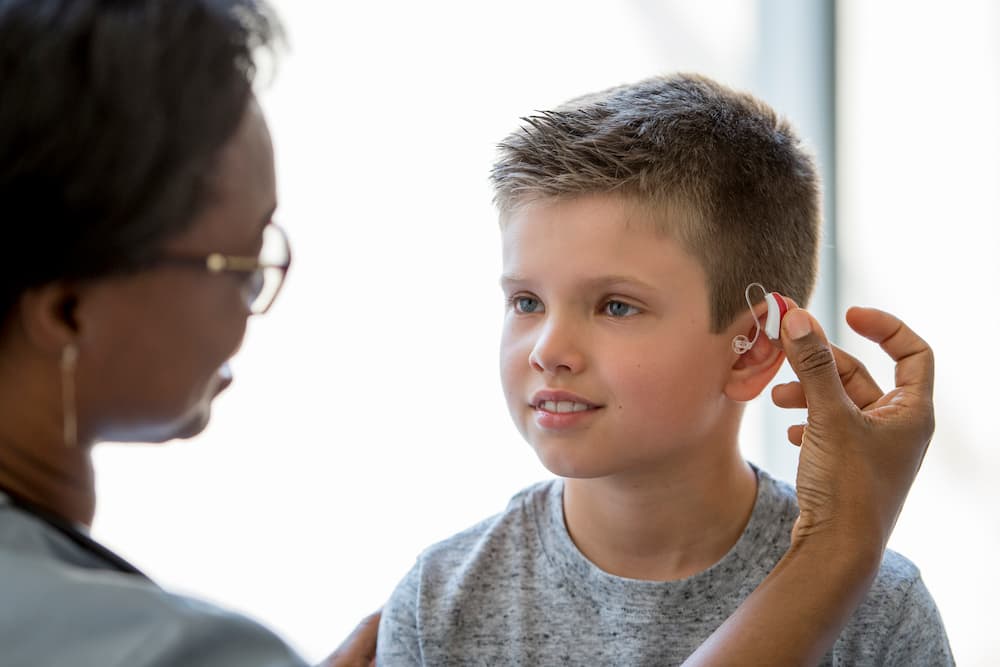 A young boy wearing hearing aid