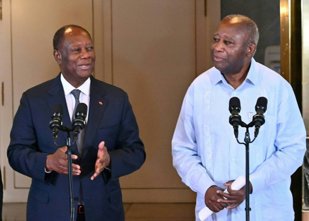 Ivory Coast President Alassane Ouattara (L) speaks next to his predecessor Laurent Gbagbo after a meeting at the presidential palace in Abidjan in July 2022