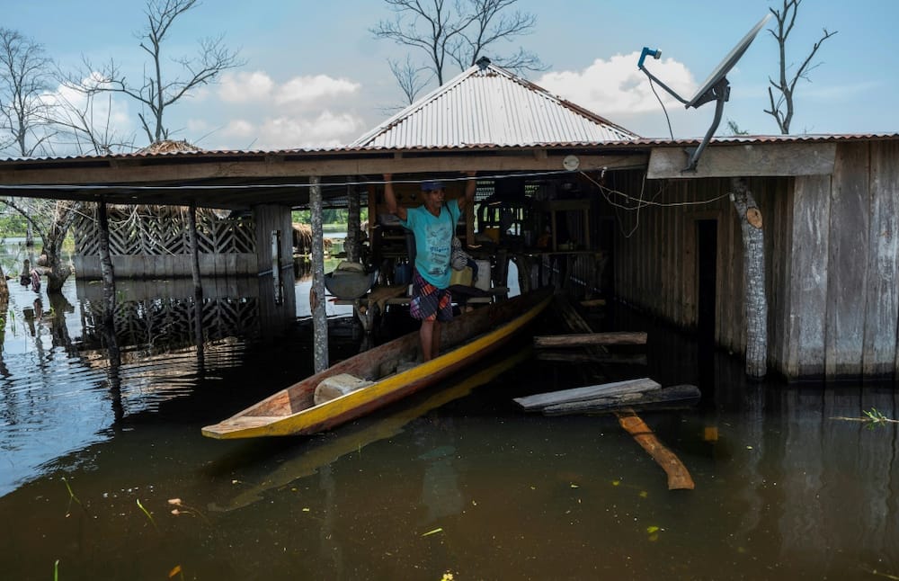 Residents travel by canoe from one house to the other. Luckier households, where the water has receded, have to contend with the mud