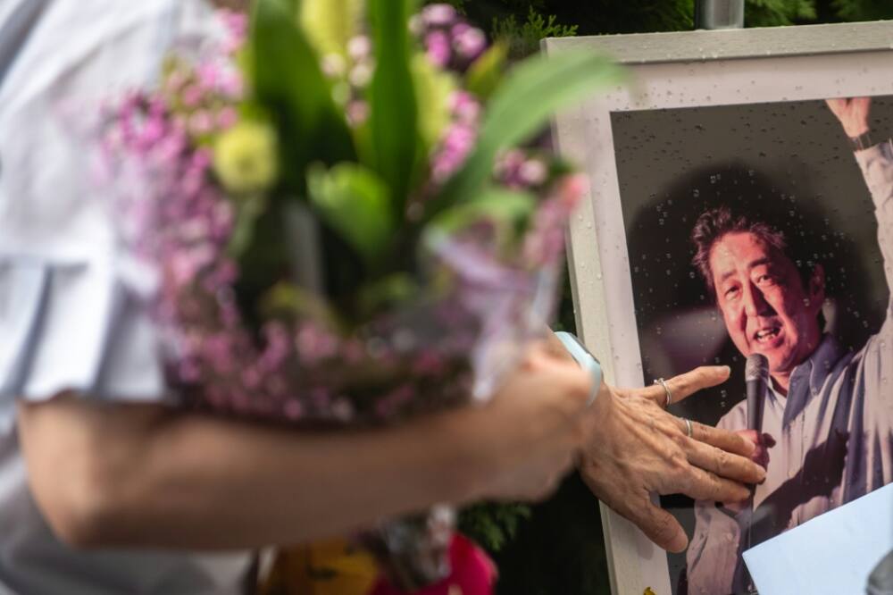 As bouquet after bouquet was placed on the table, it became a makeshift altar adorned by framed photos