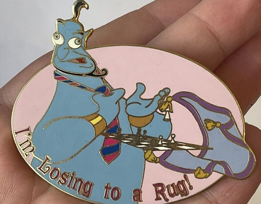 A person holding the Disney Auction Aladdin Genie Pin
