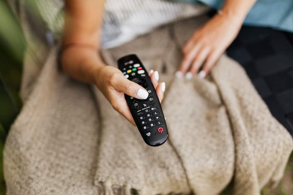 A woman using a DStv remote
