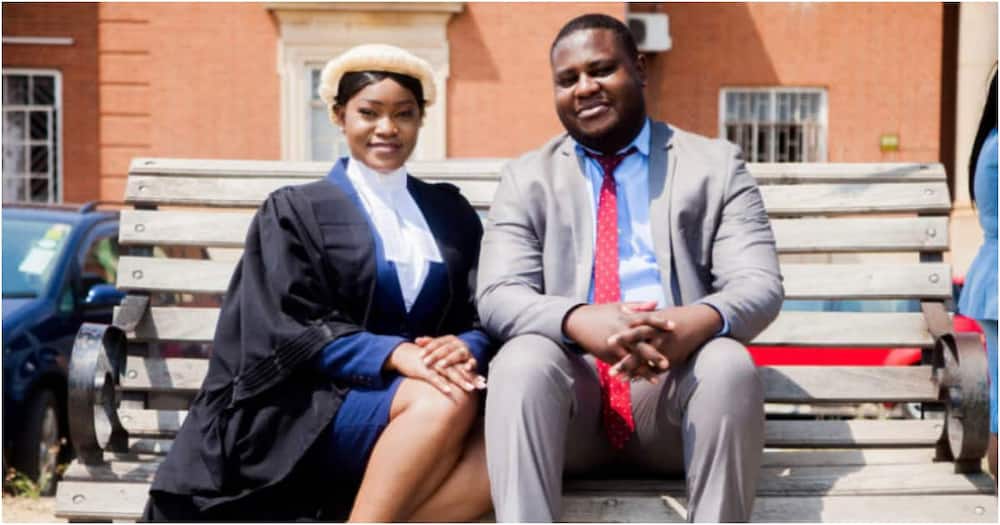 Man poses with his wife as she becomes a lawyer