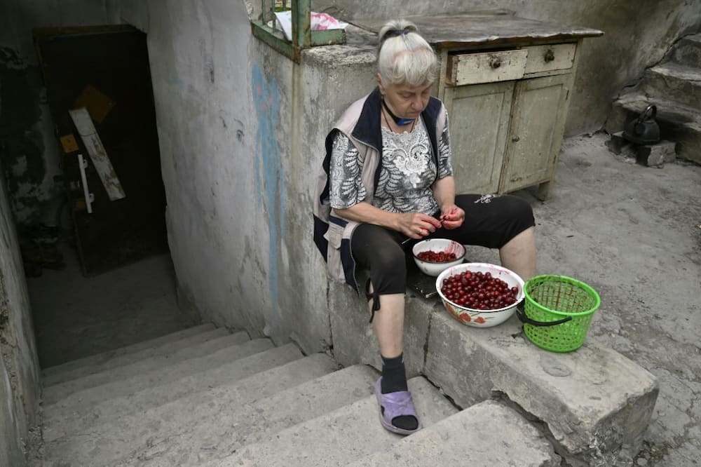 Three months stuck in a cellar: Lyudmila pits cherries outside her basement in Siversk as Russian forces draw closer