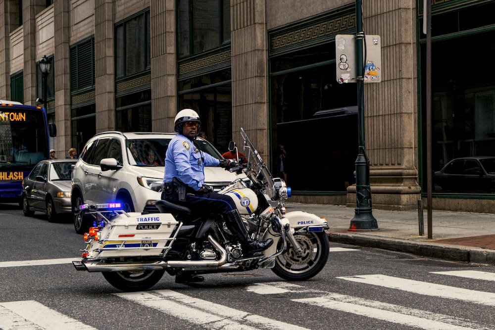 A traffic officer on a motorcycle at a zebra crossing