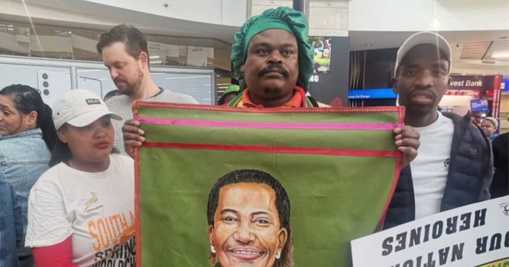 Rasta holding a portrait of Banyana Banyana's Desiree Ellis at OR Tambo Airport