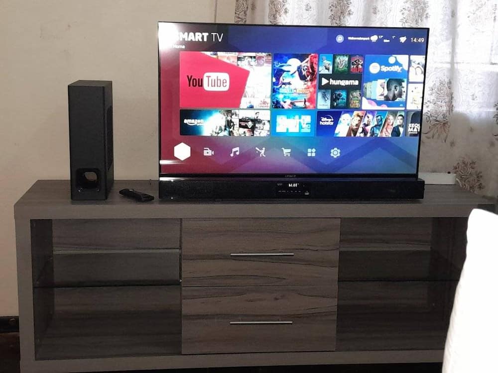 Woman shares a look at her TV and speaker on the table.
