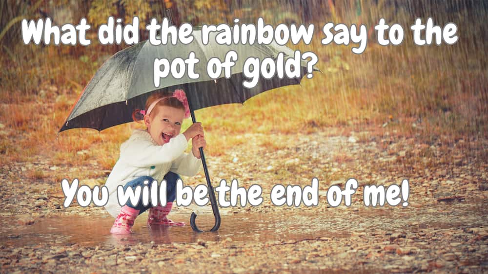 Little girl with an umbrella playing in the rain