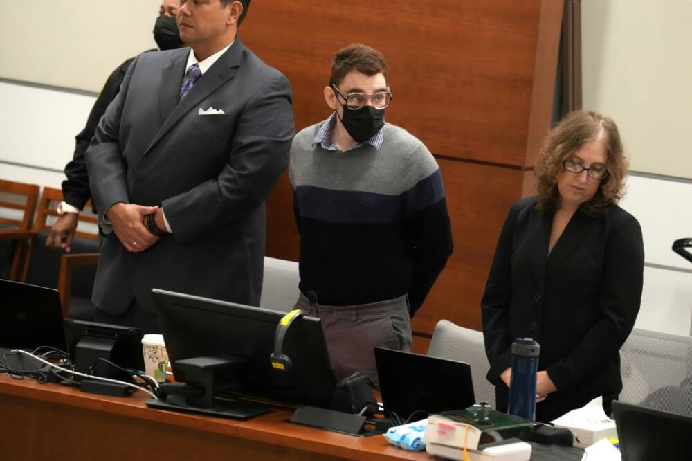 Nikolas Cruz (C), who pleaded guilty to 17 counts of murder for a 2018 shooting at Marjory Stoneman Douglas High School, stands as his sentencing trial opens in Florida