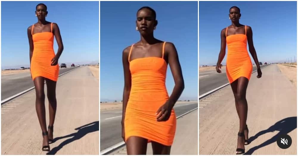 Very tall lady models in on roadside pathway