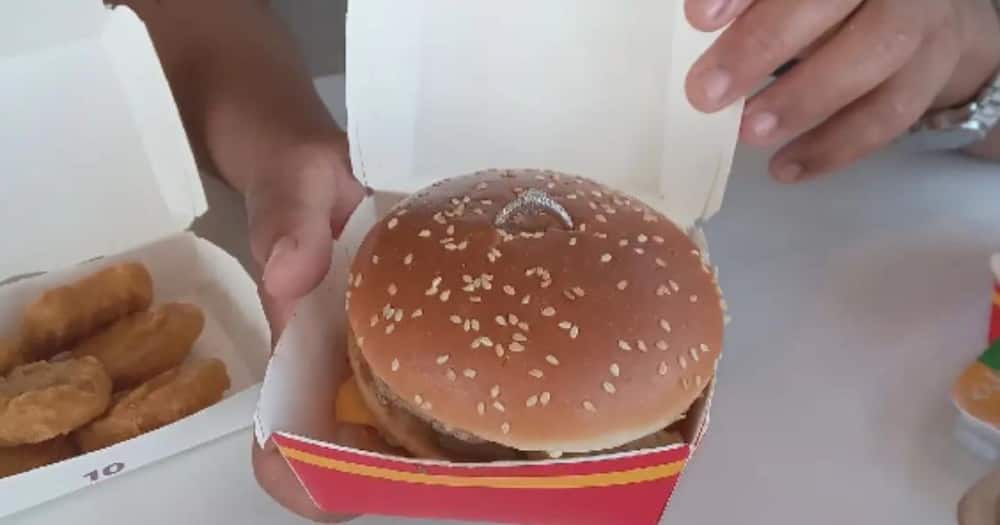 A gentleman proposed to his woman at McD's with a burger.