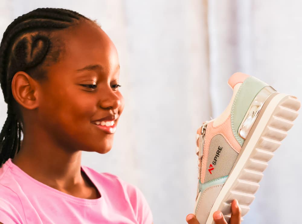 Girl holding Nspire sneaker