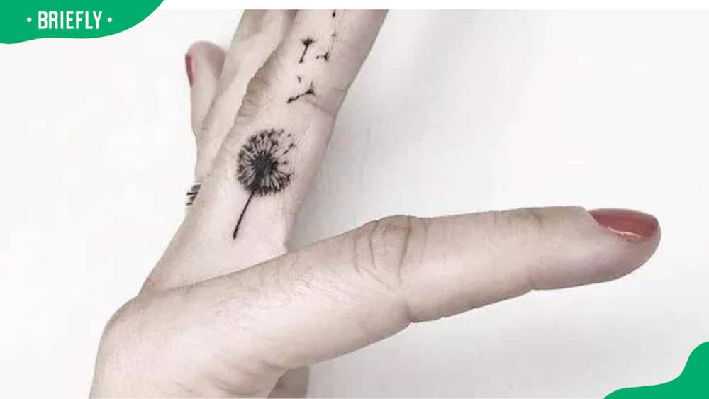 A detailed dandelion finger tattoo