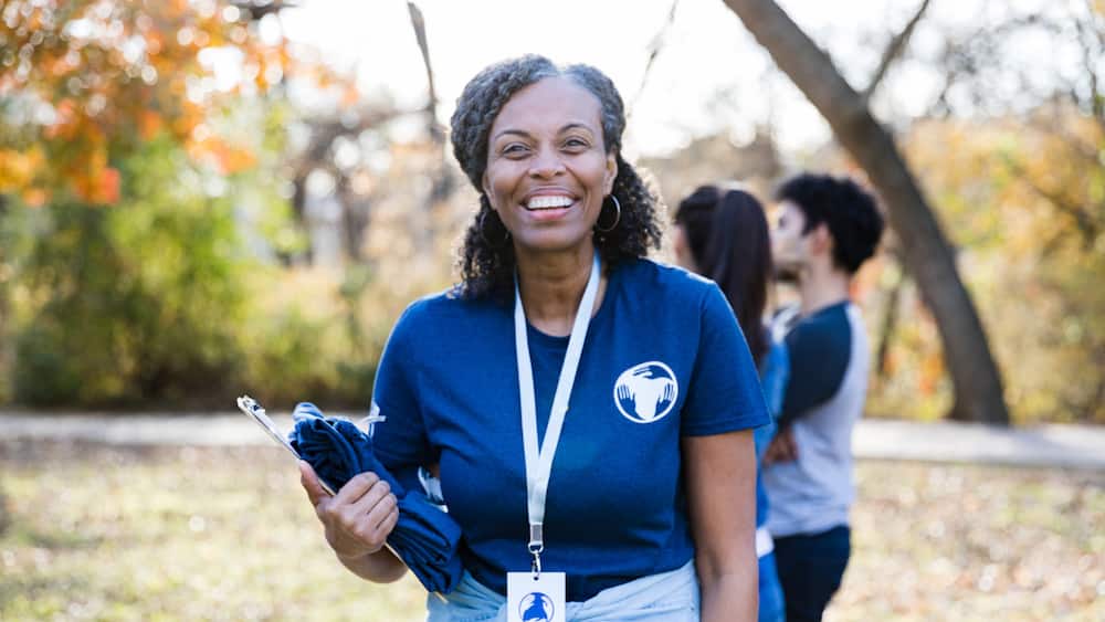 Portrait of a woman is leading a group of volunteering during a community cleanup day.