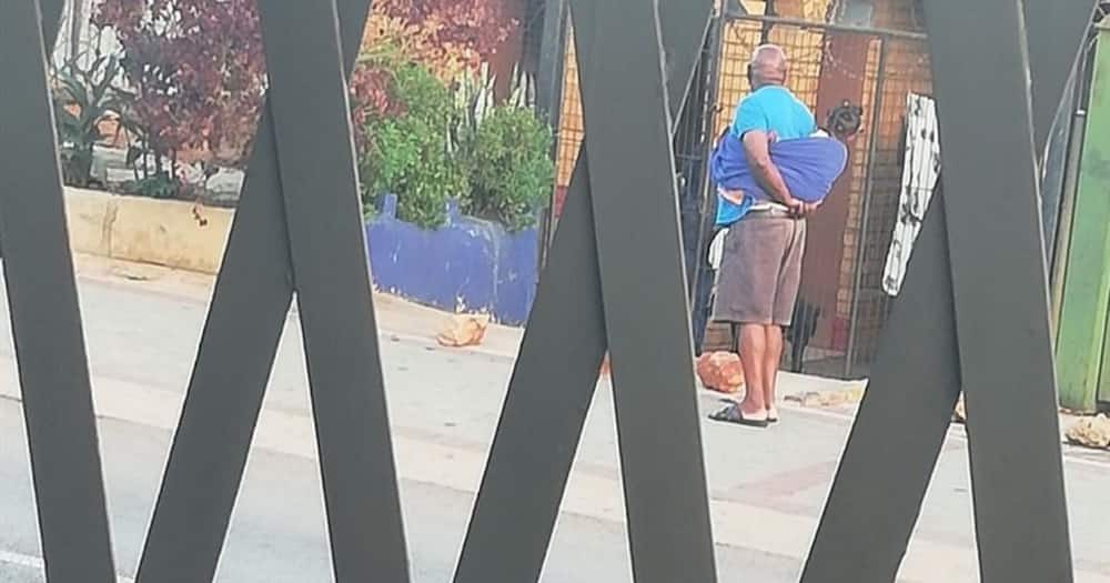 Mzansi swoons over grandpa carrying little one on his back with towel