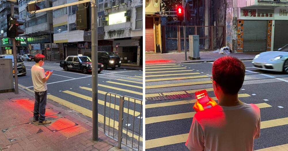 Man on mobile phone cross the road at a pedestrian crossing. Ho