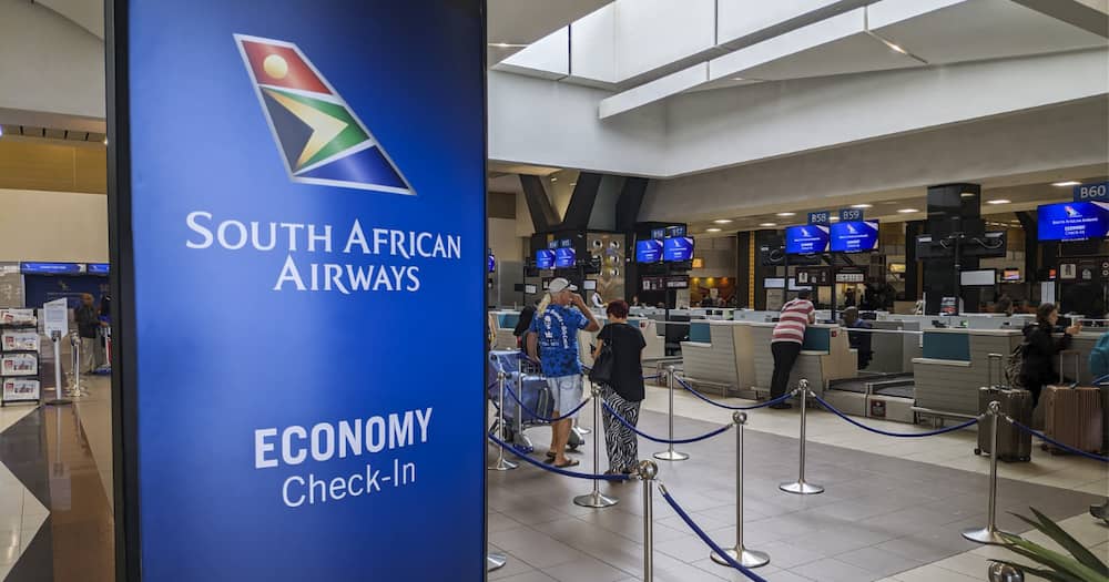 Passengers wait at the check-in counters for South African Airways (SAA), flights at OR Tambo International Airport in Johannesburg