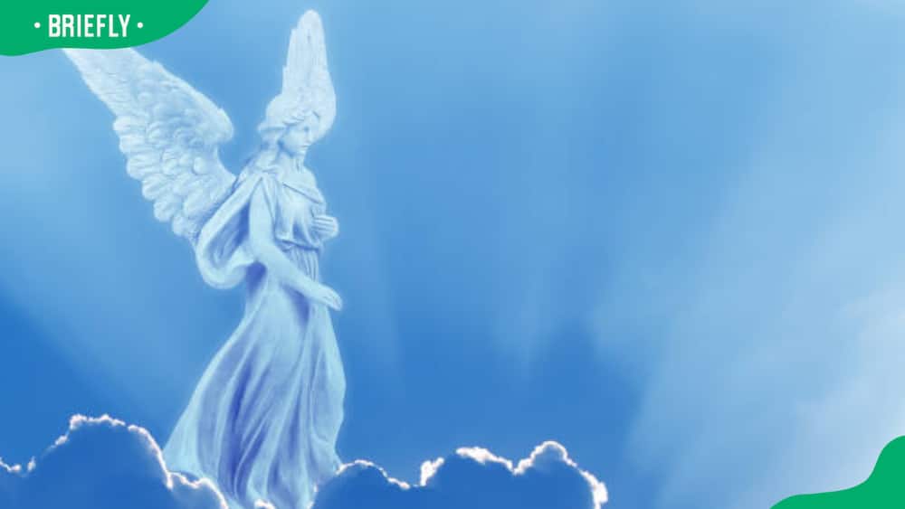 An angel on a white cloud against a clear blue sky with copy space