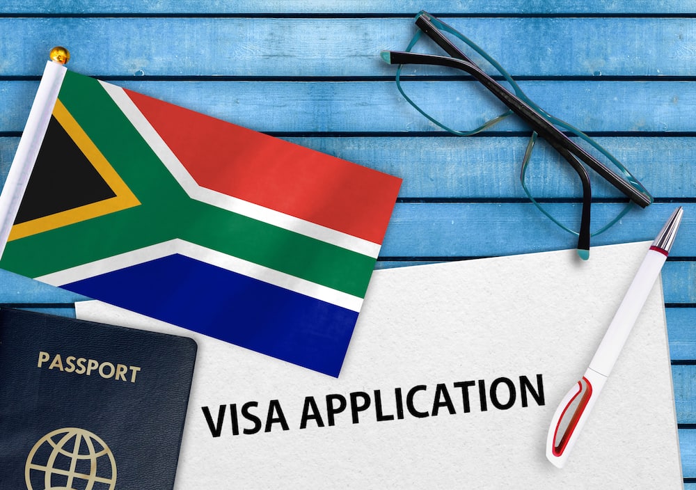A South African flag, passport, and visa application form