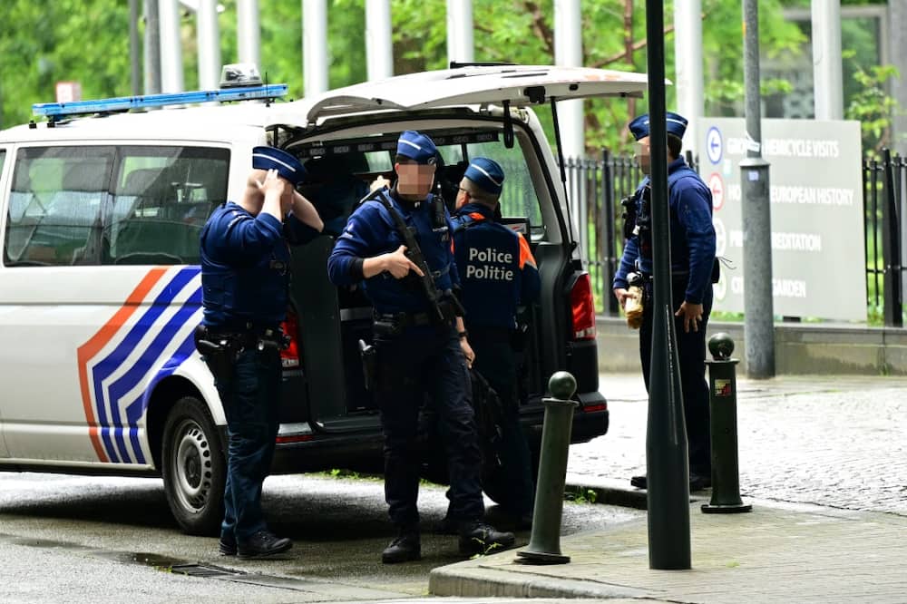 Belgian police stand guard during searches conducted at the European Parliament building as part of a probe into suspected Russian interference