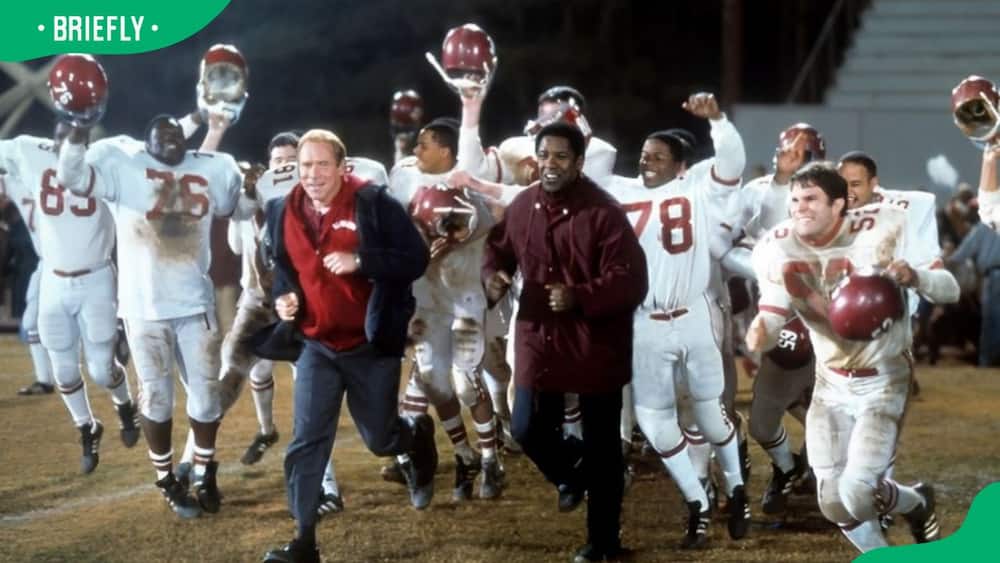 Will Patton and Denzel Washington running out onto the field in a scene from Remember The Titans in 2000