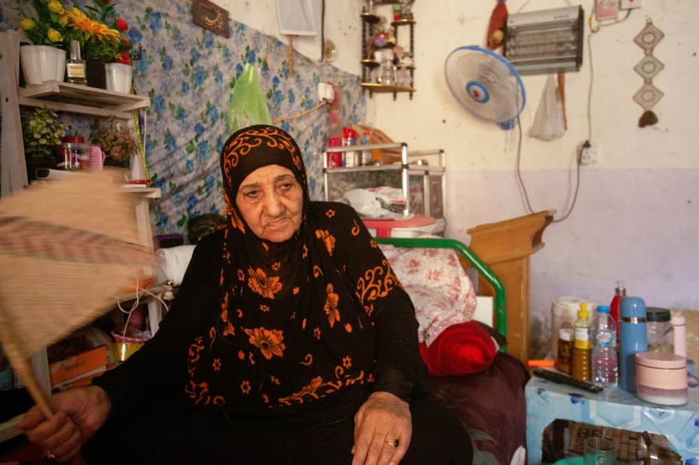 Um Mohammed sits inside her home in Iraq's southern city of Basra. Iraq, battered by decades of conflict that has sapped its infrastructure, is struggling with droughts, repeated sandstorms, desertification and a drop in river levels