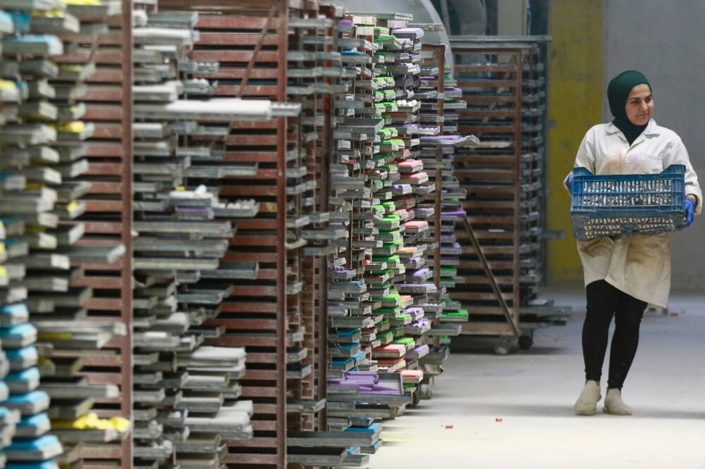 A worker carries chalk poducts at the company which started years ago with just two rooms and just five employees