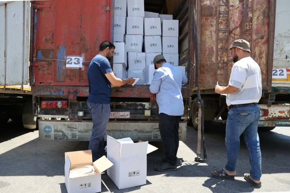 Customs officers inspect an aid convoy at the Bab al-Hawa border crossing on July 8: more than 4,600 aid trucks have crossed this year
