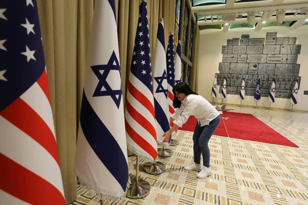 National flags being readied for display at the residence of Israel's president, ahead of Joe Biden's first visit as US head of state