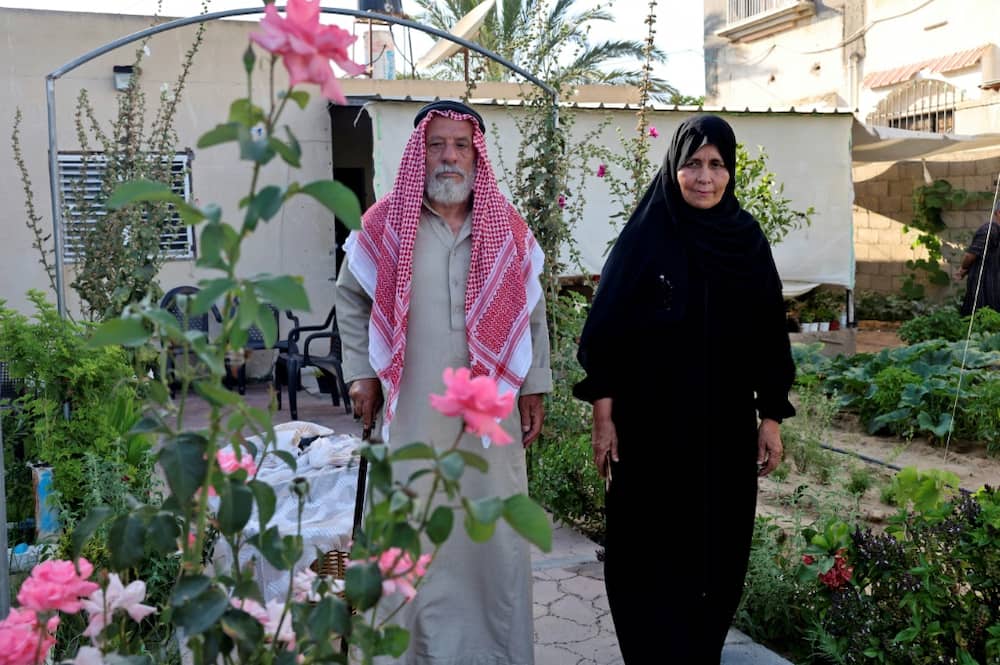 Suleiman and Nazmiya Baraka walk in their garden