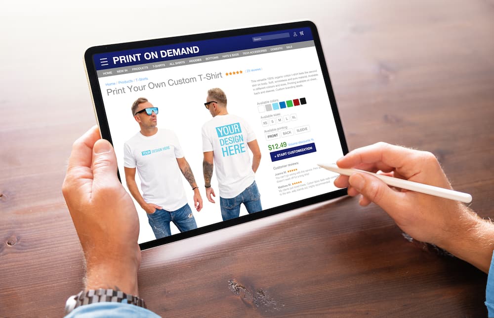 A man creating custom design t-shirts on Print-on-Demand service website
