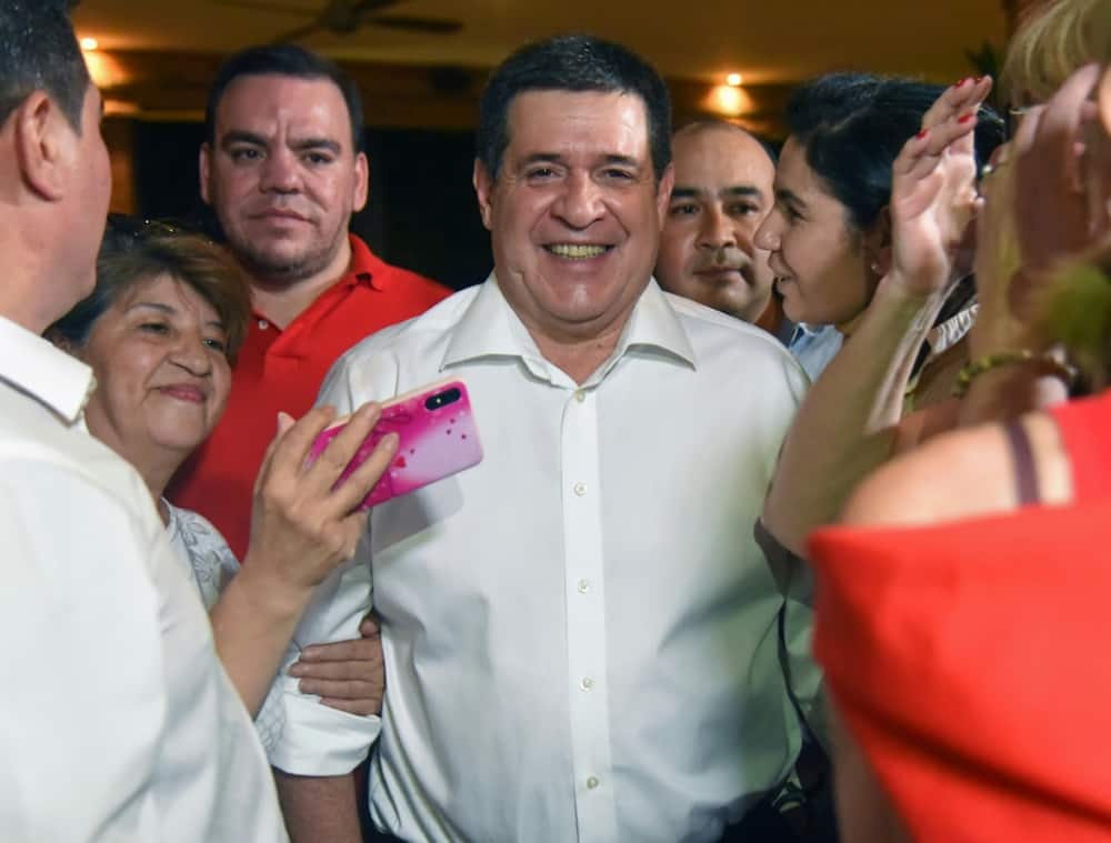 Former Paraguayan president Horacio Cartes takes pictures with supporters in Asuncion on November 19, 2019