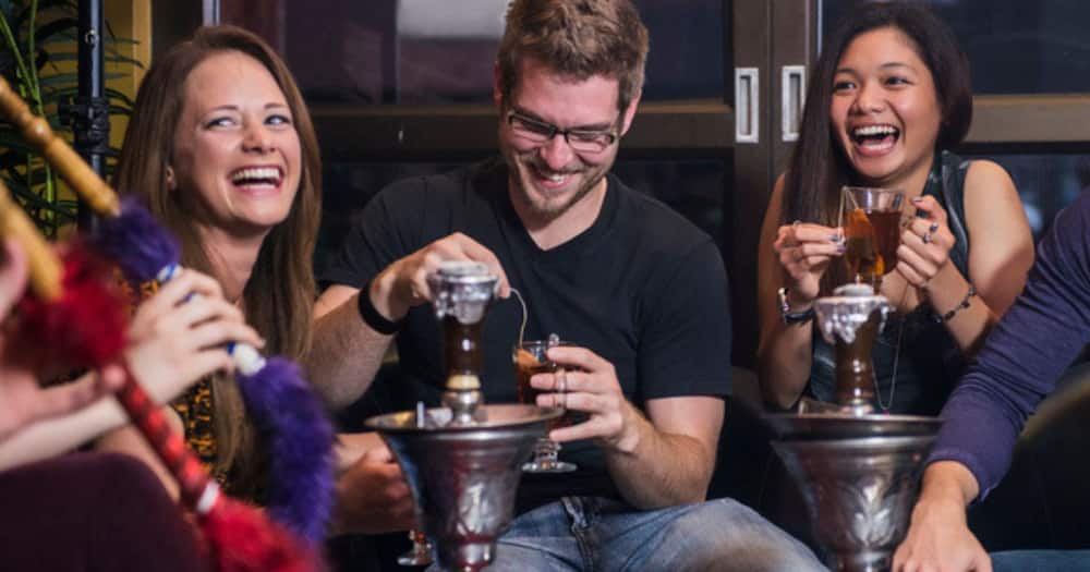 Stock image of friends smoking hubbly bubbly at the club