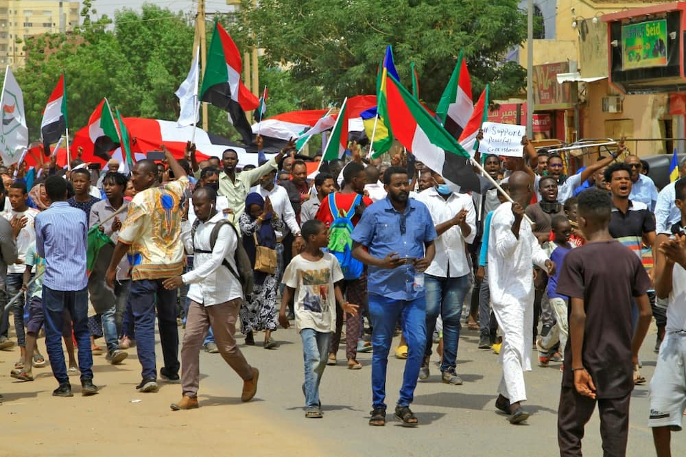 Protesters waving national flags march in an anti-coup demonstration in southern Khartoum on July 26, 2022