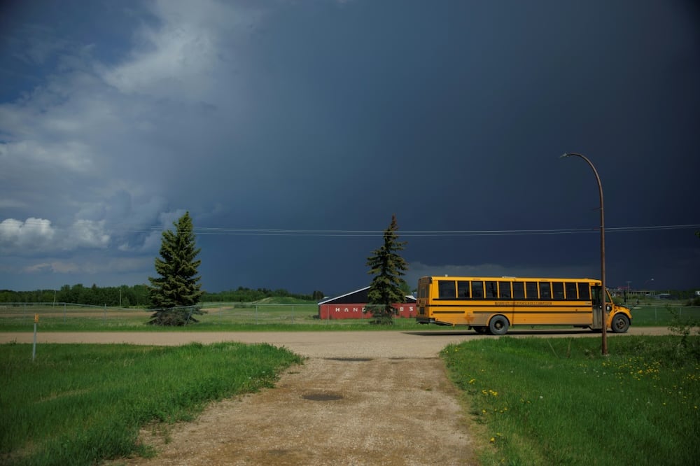 A yellow school bus on June 7 passes an empty lot where the Ermineskin Indian Residential School once stood in the Indigenous community of Maskwacis, Alberta. Pope Francis' end of July visit to Canada in which he is to offer apologies for more than a century of abuses at Indigenous residential schools, is talk of the town here, and surrounded with immense hope
