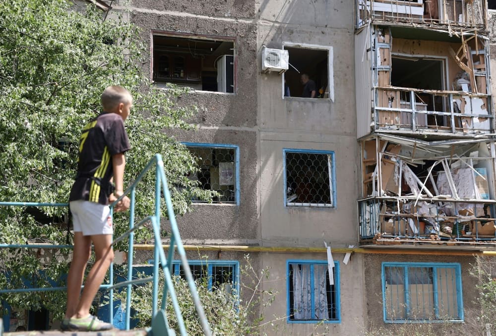 A boy surveys a damaged block of flats in Konstantinovka, hit three times in recent days as Russia intensifies its eastern offensive
