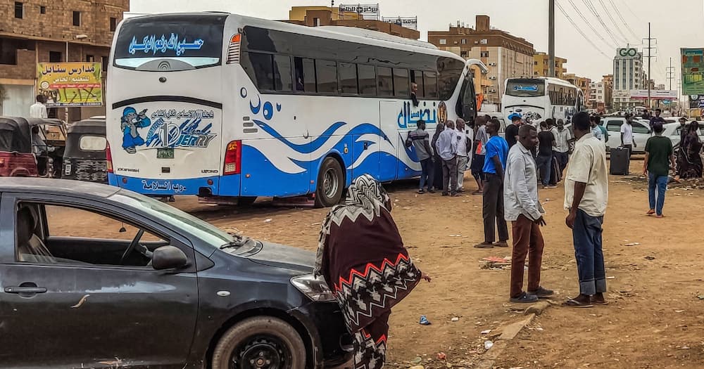 People prepare to board a bus departing from Khartoum in the Sudanese capital's south on April 24, 2023, as battles rage in the city between the army and paramilitaries