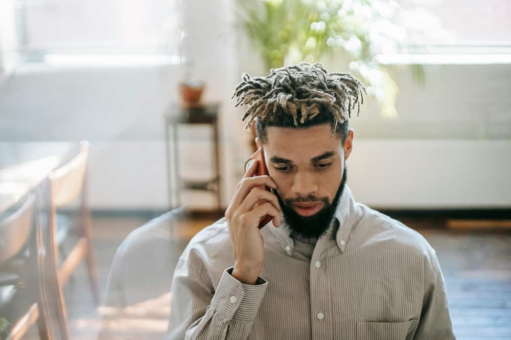 A young man in dreadlocks making a phone call
