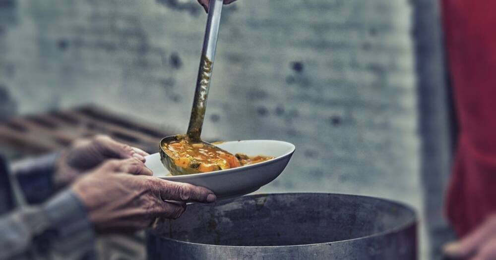Homeless and hungry person served soup