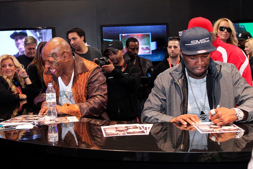 Mike Tyson and 50 Cent signing autographs