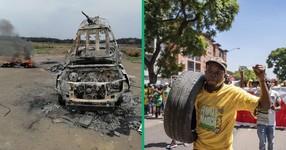 A car torched, and a protester carrying a tyre he's about to burn on the street